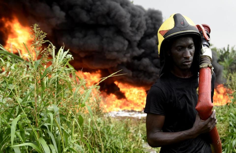 A firefighter works to put out the fire from a ruptured oil pipeline near Lagos.