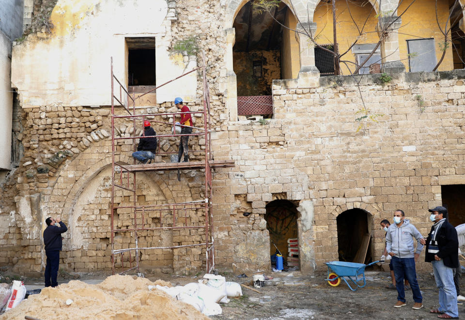 Architects and workers renovate the long-abandoned 200-year-old al-Kamalaia school, in the old quarter of Gaza City, Sunday, Dec. 20, 2020. Less than 200 of these old houses are still partly or entirely standing, according to officials and they are threatened by neglect, decaying and urban sprawl. (AP Photo/Adel Hana)