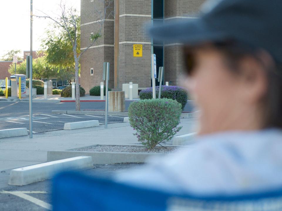 Nicole, 52, watches a ballot-drop box while sitting in a parking lot in Mesa, Arizona, on October 24, 2022.