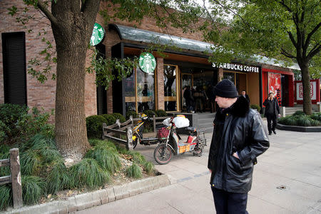 People walk in front of a Starbucks after a vehicle caught fire and mounted the pavement, ploughing into pedestrians in a busy part of central Shanghai, China February 2, 2018. REUTERS/Aly Song