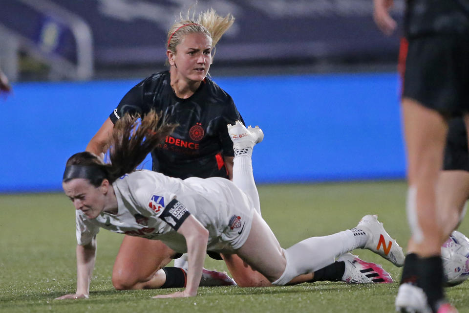 Portland Thorns midfielder Lindsey Horan, rear, reacts after taking down Washington Spirit midfielder Rose Lavelle during the second half of an NWSL Challenge Cup soccer match at Zions Bank Stadium on Sunday, July 5, 2020, in Herriman, Utah. (AP Photo/Rick Bowmer)