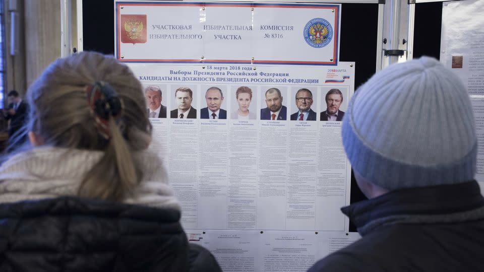 Russian citizens at the Russian embassy in Berlin, Germany, look at a list of candidates in the 2018 Russian presidential election. - Joerg Carstensen/picture-alliance/dpa/AP