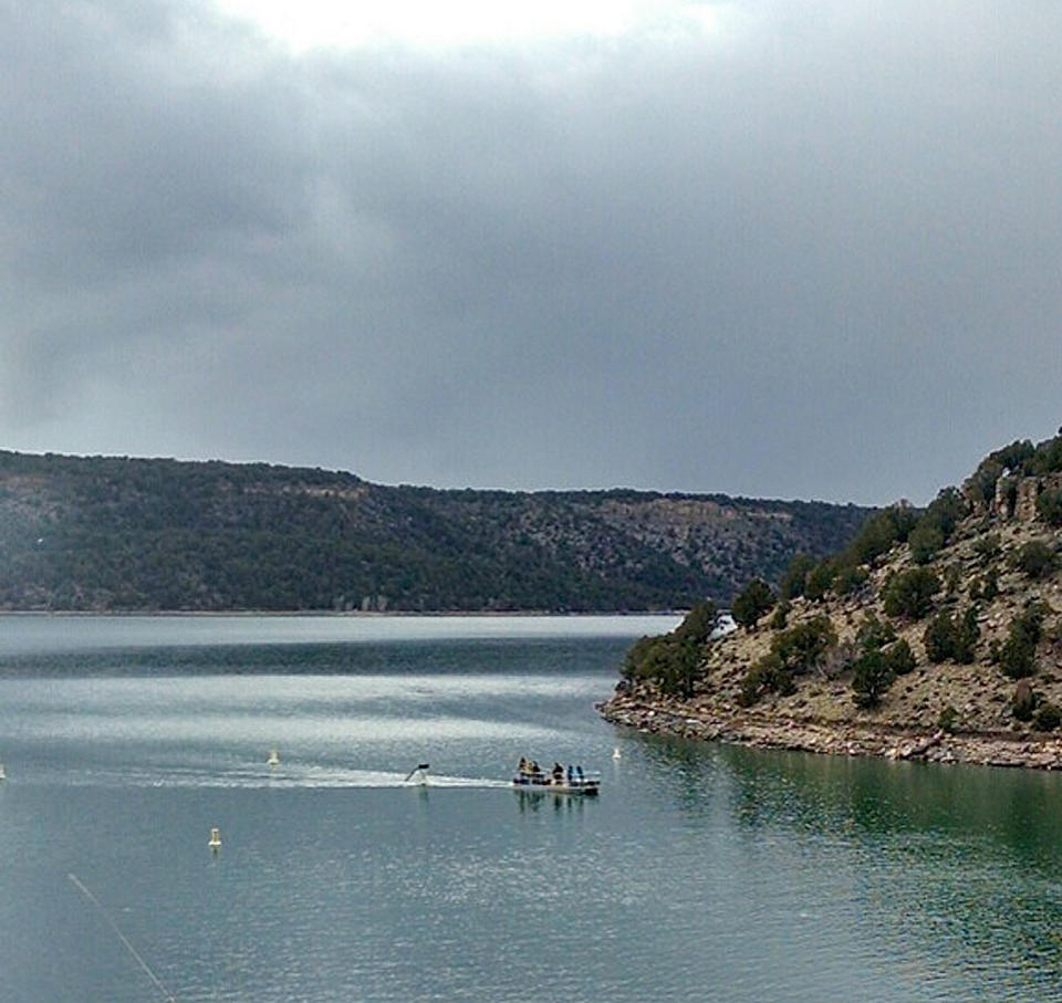 This photo provided by the Ouray County Plaindealer shows rescue personnel towing the tail second of a plane on Saturday, March 22, 2014 after it was recovered from the Ridgeway Reservoir south of Montrose. Colo. The plane believed to be carrying five people crashed into a reservoir in southwestern Colorado and authorities say all are feared dead. Divers are to be used Sunday to search for victims and to recover the rest of the plane. (AP Photo/Ouray County Plaindealer, Patrick Moore) MANDATORY CREDIT