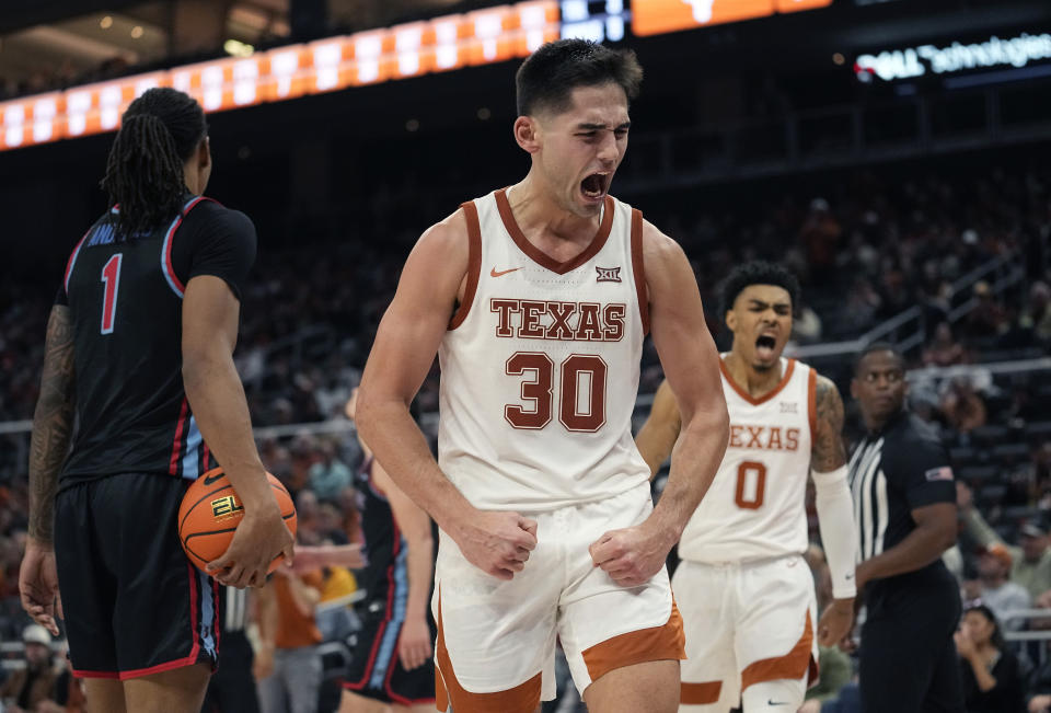 Texas forward Brock Cunningham (30) and guard Chris Johnson (0) celebrate a score against Delaware State during the second half of an NCAA college basketball game, Friday, Nov. 10, 2023, in Austin, Texas. (AP Photo/Eric Gay)