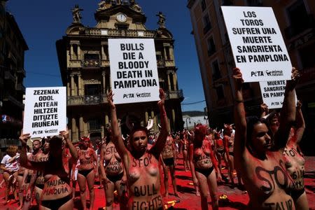 Animal rights protesters hold placard after breaking mock banderillas containing red powder during a demonstration for the abolition of bull runs and bullfights a day before the start of the famous running of the bulls San Fermin festival in Pamplona, northern Spain, July 5, 2017. REUTERS/Eloy Alonso TEMPLATE OUT