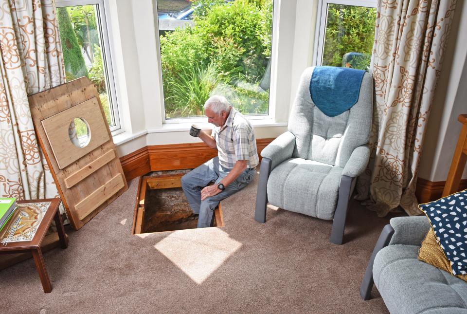 CATERS NEWS (PICTURED- Colin admits that when he eventually reaches the bottom of the well he would love to extend it out of the ground and turn it into a coffee table) - A grandad has spent the last decade digging out a 17ft deep medieval well in his living room after noticing a slight dip in the floor when redecorating. Colin Steer, from Plymouth, discovered the well after he noticed a dip in the floor while redecorating his living room ten years ago and has since spent the last decade digging out the 17ft well. The 70-year-old believes that the well could date back to medieval times after discovering an old sword while digging out the well and plans of the site suggests that the well could date back to the 1500s. Colin said: 