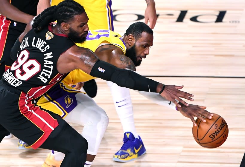 ORLANDO, FLORIDA OCTOBER 6, 2020-Lakers LeBron James and Heat's Jae Crowder battle for loose ball in the 2nd quarter in Game 4 of the NBA FInals in Orlando Sunday. (Wally Skalij/Los Angeles Times)