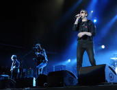 Kasabian lead singer Tom Meighan (R) and guitarists Jay Mehier and Sergio Pizzorno (L-R background), perform at Dubai Sevens stadium, Friday, February 10, 2012. The British band belted out such classics as Shoot The Runner and Club Foot to what seemed to be a predominantly British audience. Photograph: Peter Harrison/Yahoo! Maktoob