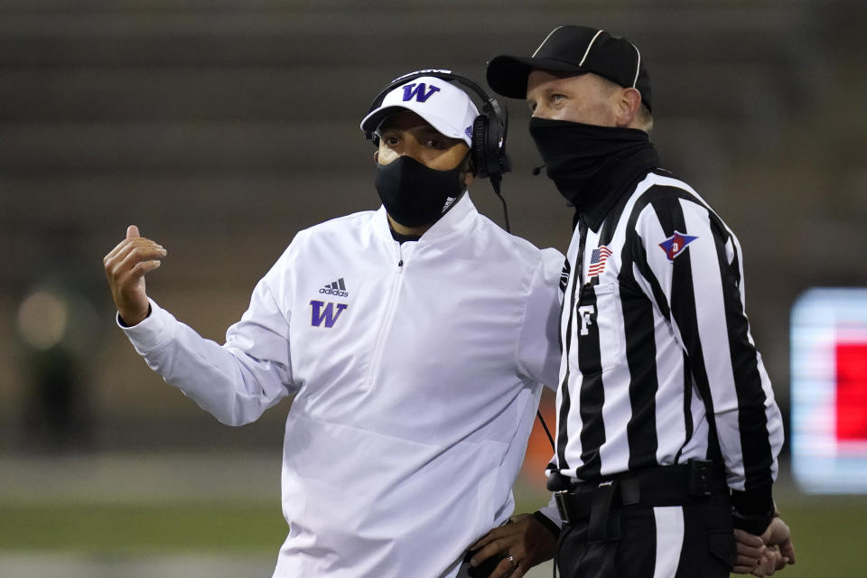 Washington coach Jimmy Lake talks with field judge Todd Migchelbrink during the first half of an NCAA college football game Saturday, Nov. 21, 2020, in Seattle. (AP Photo/Elaine Thompson)