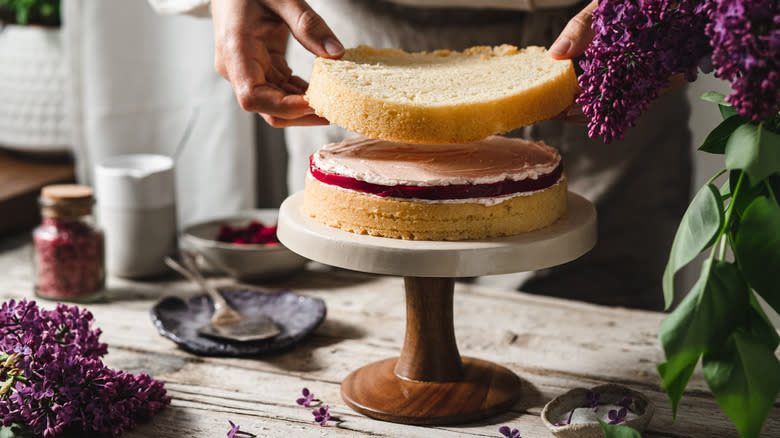 person layering cake