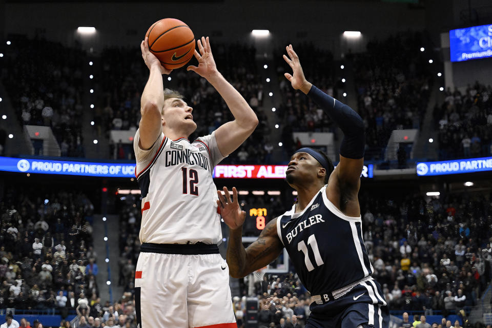 UConn guard Cam Spencer (12) shoots as Butler guard Jahmyl Telfort (11) defends in the first half of an NCAA college basketball game, Tuesday, Feb. 6, 2024, in Hartford, Conn. (AP Photo/Jessica Hill)