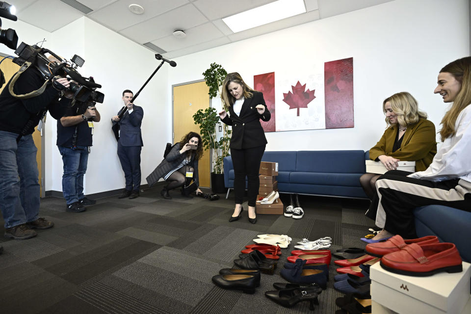 Deputy Prime Minister and Minister of Finance Chrystia Freeland takes a few steps in her new pair of shoes from direct-to-consumer footwear company Maguire, with company founders Myriam Belzile-Maguire, second from right, and Romy Belzile-Maguire, right, during a pre-budget photo op in her office in Ottawa, Monday, April 15, 2024. THE CANADIAN PRESS/Justin Tang