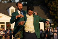 Dustin Johnson helps Hideki Matsuyama, of Japan, put on the champion's green jacket after winning the Masters golf tournament on Sunday, April 11, 2021, in Augusta, Ga. (AP Photo/David J. Phillip)