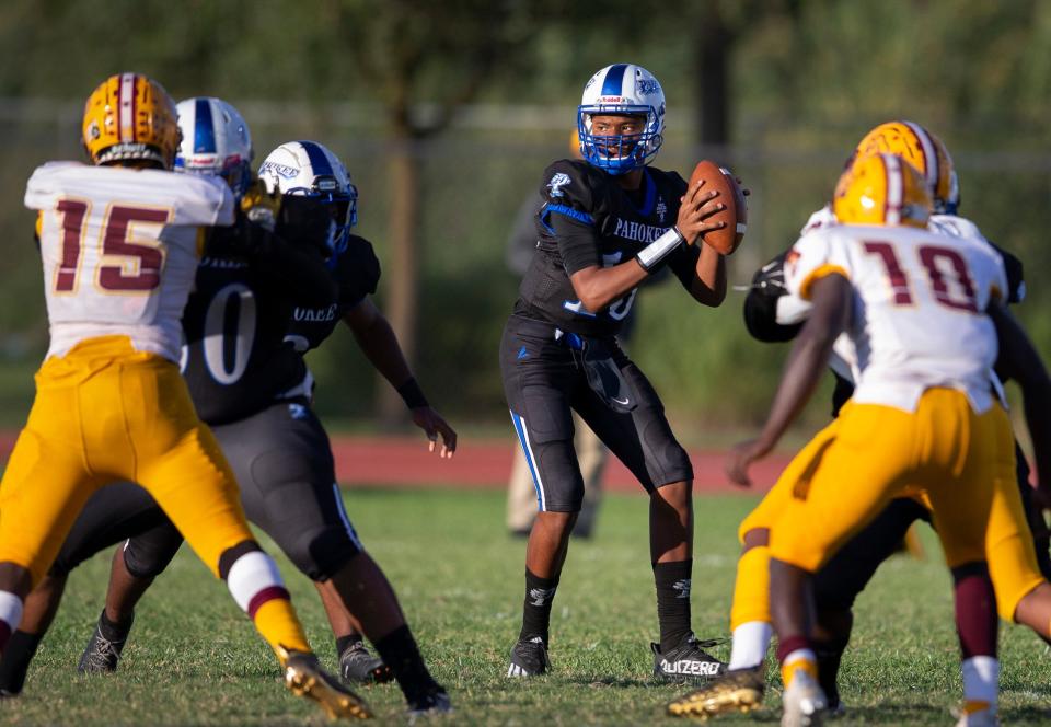 Pahokee quarterback Austin Simmons looks for an open receiver during game against Glades Central in the Muck Bowl in Pahokee last November.