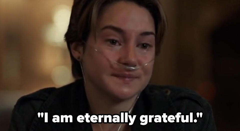 Person with a nasal cannula, looking emotional in a dimly lit room