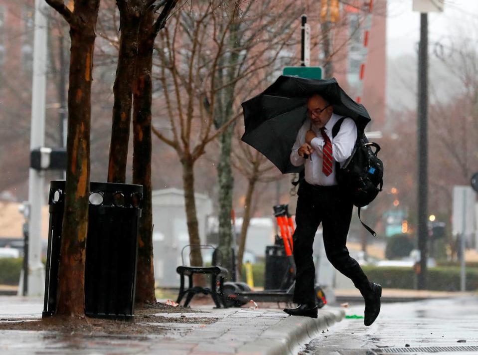 A person crosses Corcoran Street as a winter storm brings heavy rain and wind on Tuesday, Jan. 9, 2024, in Durham, N.C. Kaitlin McKeown/kmckeown@newsobserver.com