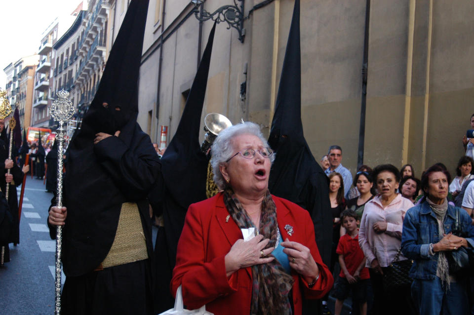 A woman reads a poem for Jesus as Catholics walk during the silence procession of Maundy Thursday in Madrid, Spain.