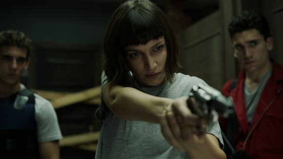 A scene from Netflix program Money Heist, with female character pointing a gun.