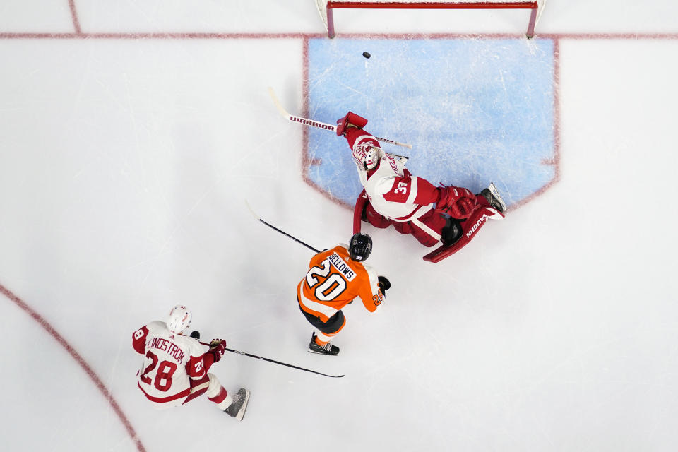 Philadelphia Flyers' Kieffer Bellows (20) scores a goal past Detroit Red Wings goaltender Alex Nedeljkovic (39) as Gustav Lindstrom (28) defends during the second period of an NHL hockey game, Saturday, March 25, 2023, in Philadelphia. (AP Photo/Derik Hamilton)