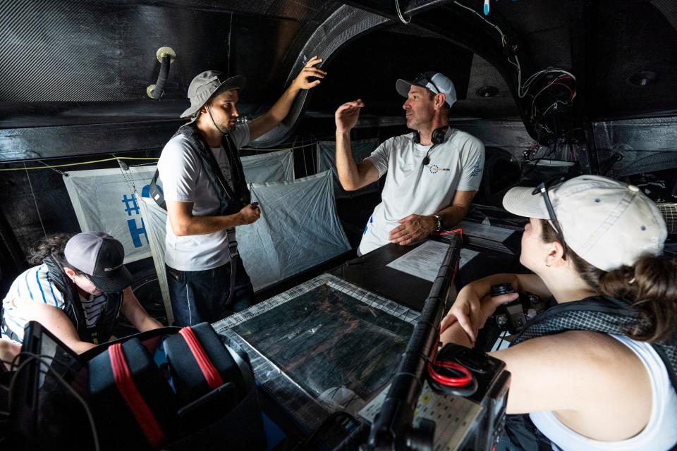 Newport Daily News reporter Zane Wolfang, second from left, chats with 11th Hour Racing navigator Simon Fisher during a sail on July 22, 2022.