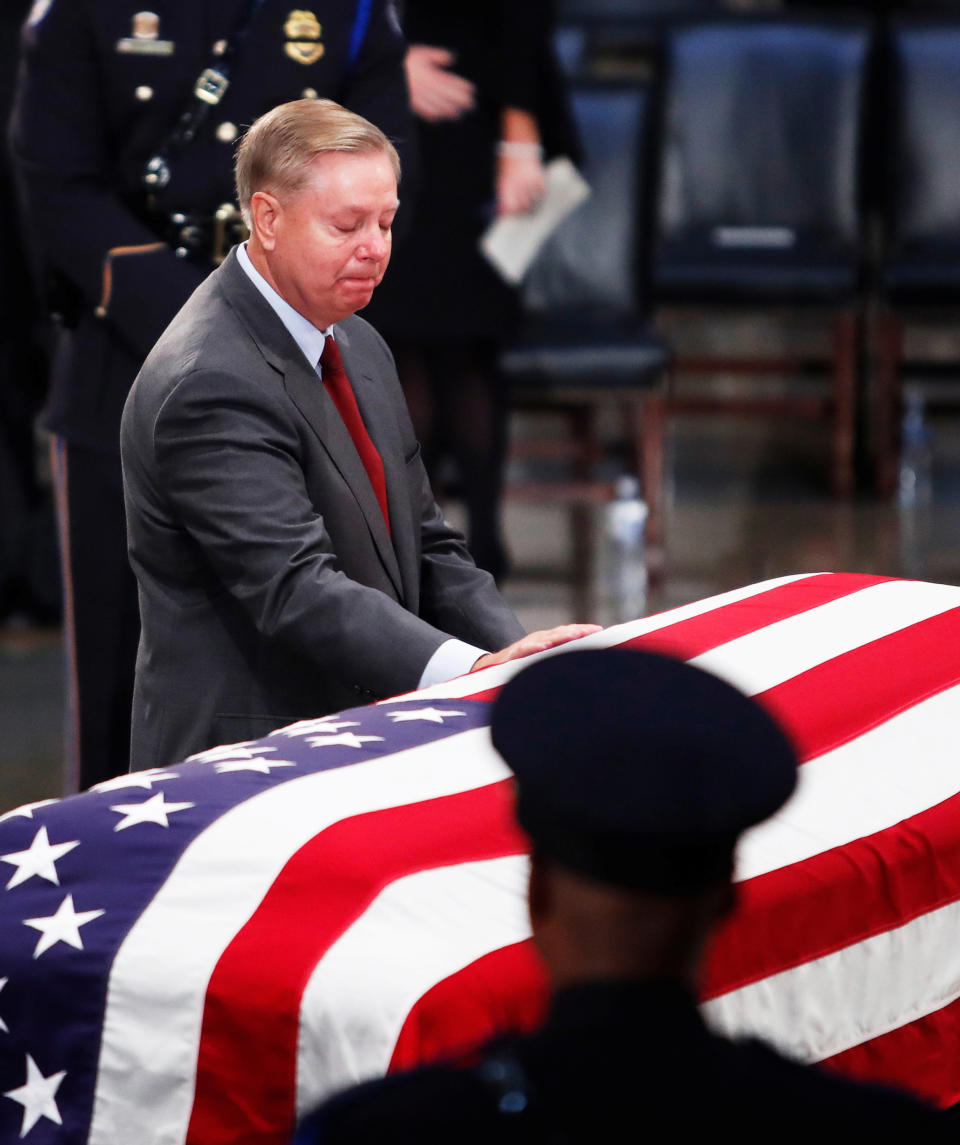 Sen. Lindsey Graham lays his hand on the casket.