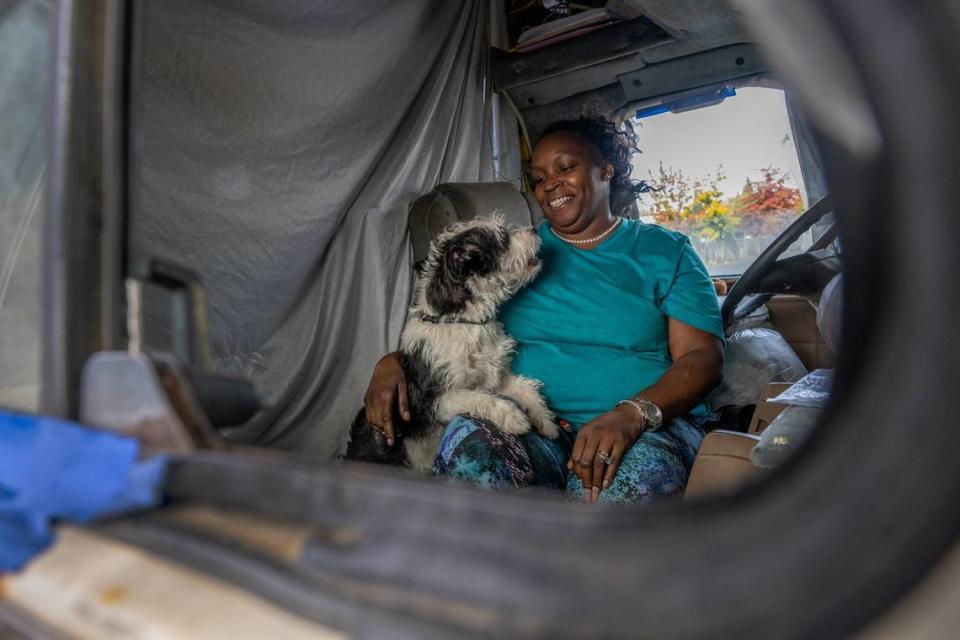 Rosita Howard, 45, holds her dog Jack, as her RV is parked on Winona Way near the planned “Safe Stay” parking lot in November. She hadn’t heard about the planned site. Howard said that she and her husband, an Army veteran, haven’t been able to find housing because of escalating deposits and rent.