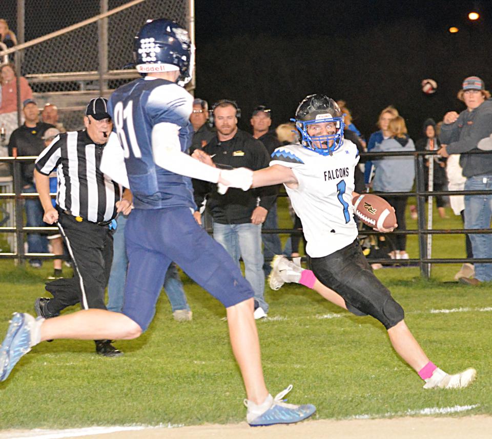 Florence-Henry quarterback Tegan Sumner (1) eludes Great Plains Lutheran's Alex Heil on the way to scoring a touchdown during their high school football game on Saturday, Oct. 1, 2022 at Watertown Stadium. Florence-Henry won 40-12.