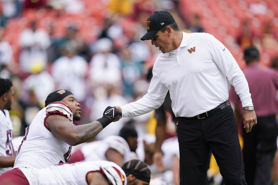 Washington Commanders head coach Ron Rivera shakes hands with defensive end Montez Sweat (90) before the start of an NFL football game against the Philadelphia Eagles, Sunday, Sept. 25, 2022, in Landover, Md. (AP Photo/Susan Walsh)