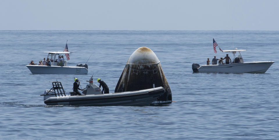 FILE - In this Sunday, Aug. 2, 2020, file photo, provided by NASA, support teams and curious recreational boaters arrive at the SpaceX Crew Dragon Endeavour spacecraft shortly after it landed with NASA astronauts Robert Behnken and Douglas Hurley on board in the Gulf of Mexico off the coast of Pensacola, Fla. The Demo-2 test flight for NASA's Commercial Crew Program was the first to deliver astronauts to the International Space Station and return them safely to Earth onboard a commercially built and operated spacecraft. Behnken and Hurley returned after spending 64 days in space. (Bill Ingalls/NASA via AP, File)