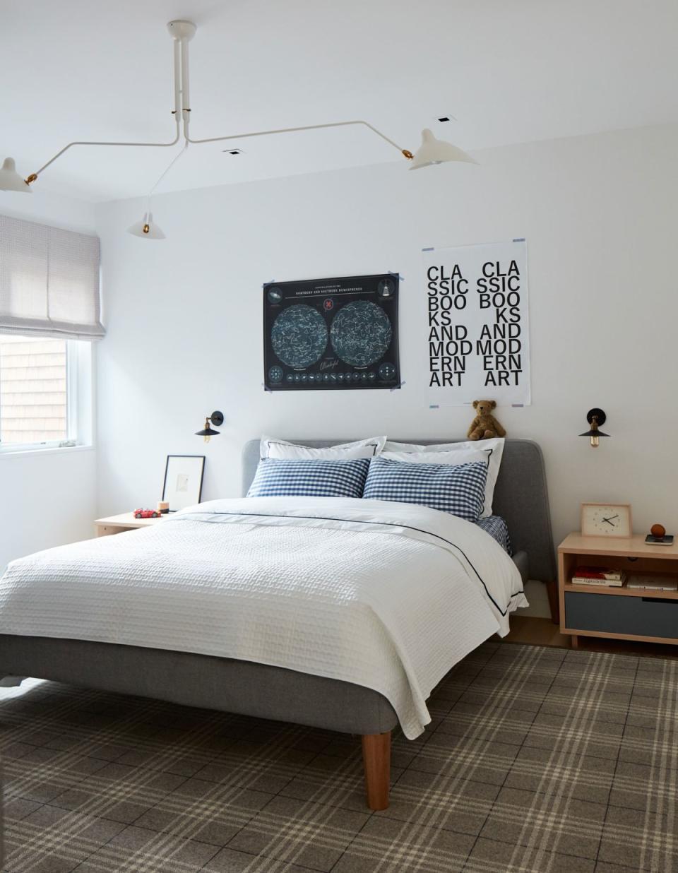 The couple’s eight-year-old son has an affinity for the color blue, and it pops up throughout his bedroom—in the checked bed sheets, the Eames desk chair and the graphic posters on the wall. Matching nightstands from Blu Dot flank the gray, flannel-upholstered bed frame, while a three-armed Serge Mouille light fixture provides a playful touch overhead.