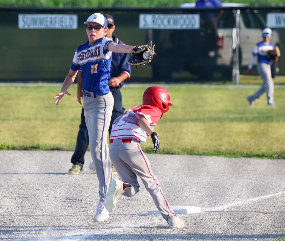 Ida first baseman Ryan Ashcroft tracks down an errant throw as Vincent Gallo ducks out of the way in the finals of the 63rd annual Monroe County Fair Baseball Tournament Wednesday. Ida won the title with a 7-5 win over Bedford Elite.