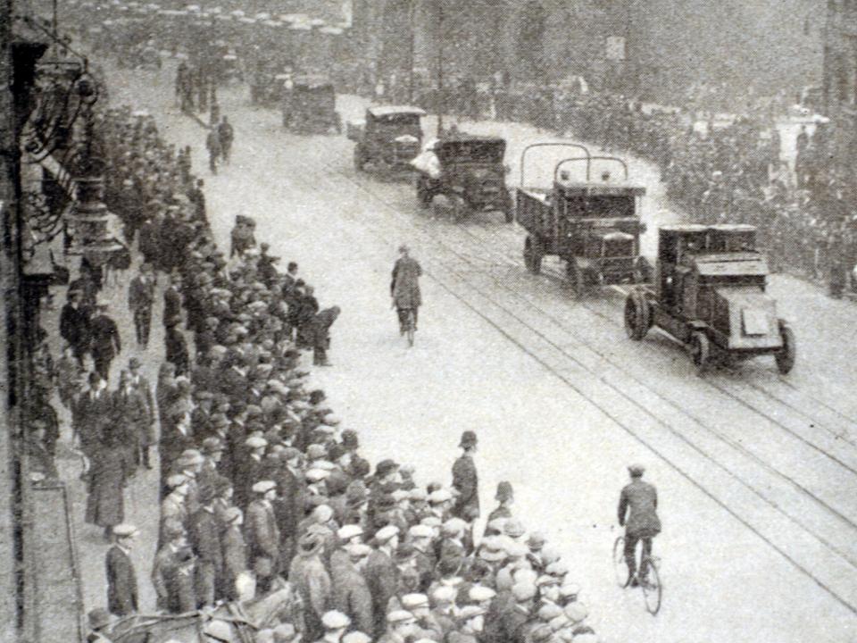 Streets filled with army tanks while men lined the streets in crowds.