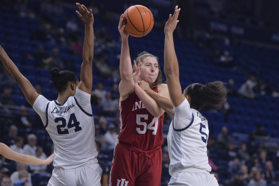 Indiana's Mackenzie Holmes (54) passes the ball as Penn State's Alexa Williamson (24) and Leilani Kapinus (5) defend during the second half of an NCAA college basketball game Thursday, Dec. 8, 2022, in State College, Pa. (AP Photo/Gary M. Baranec)