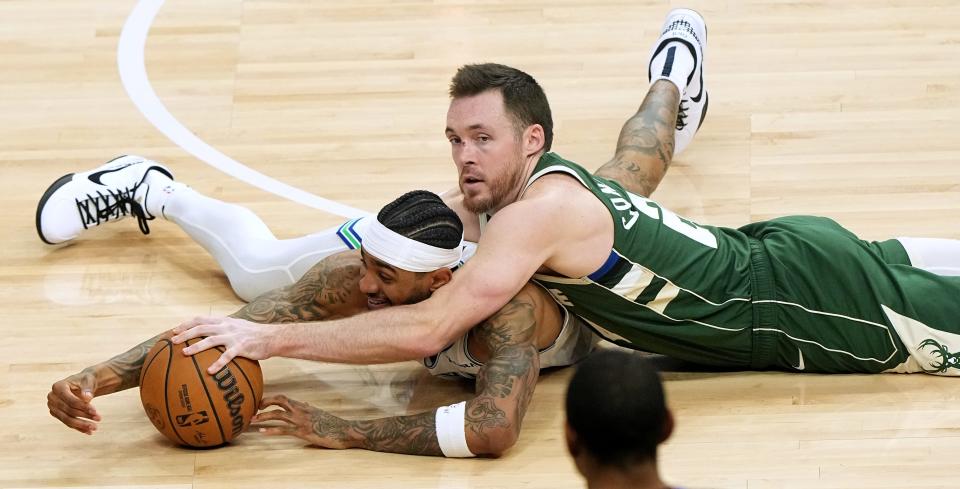 Milwaukee Bucks guard Pat Connaughton, right, vies for a loose ball with Minnesota Timberwolves guard Nickeil Alexander-Walker during a game Feb. 8 at Fiserv Forum.