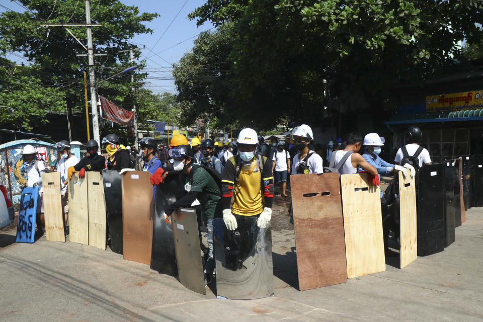 Anti-coup protesters take positions behind a makeshift barricade as armed riot policemen gather in Yangon, Myanmar, Friday, March 5, 2021. Footage of a brutal crackdown on protests against a coup in Myanmar has unleashed outrage and calls for a stronger international response. (AP Photo)