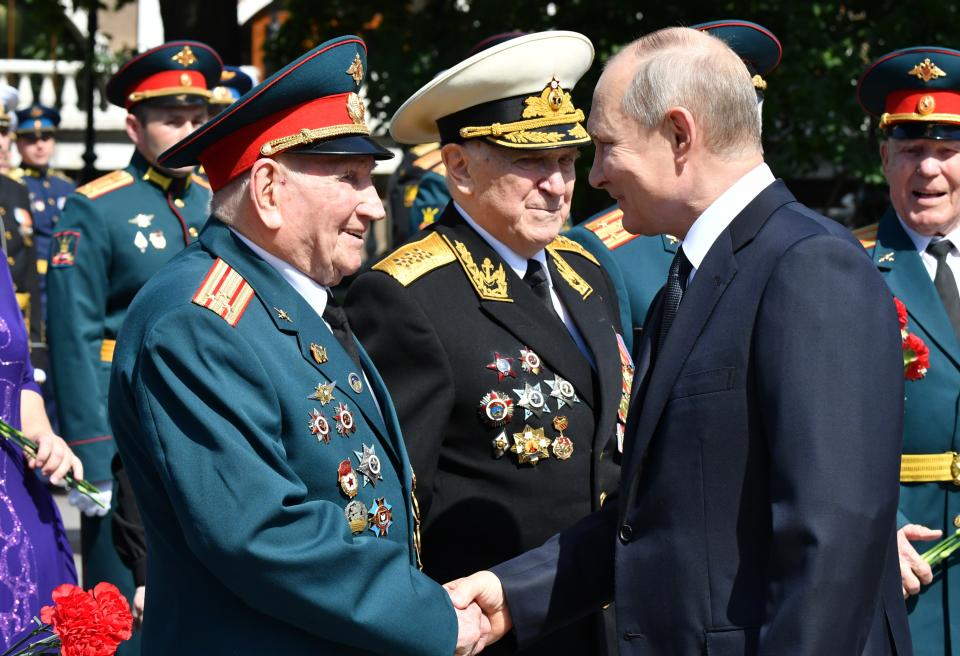 Russian President Vladimir Putin, right, greets Russian WWII veterans during a wreath laying ceremony at the Tomb of Unknown Soldier in Moscow, Russia, Tuesday, June 22, 2021, marking the 80th anniversary of the Nazi invasion of the Soviet Union. (Alexei Nikolsky, Sputnik, Kremlin Pool Photo via AP)