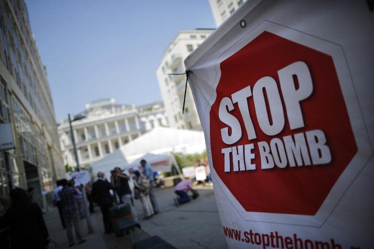 A sign which reads 'Stop the Bomb' is seen as protesters gather outside the hotel where the Iran nuclear talks meetings are being held in Vienna, Austria, July 1, 2015. International Atomic Energy Agency (IAEA) chief Yukiya Amano will be in Tehran on Thursday to discuss monitoring sensitive nuclear sites with senior officials as major powers and Iran seek a breakthrough in forging a lasting nuclear agreement. Iran and world powers gave themselves an extra week on Tuesday to reach an accord curbing Iran's nuclear programme in exchange for sanctions relief, but U.S. President Barack Obama warned there would be no deal if all pathways to an Iranian nuclear weapon were not cut off. AFP PHOTO / POOL / CARLOS BARRIA