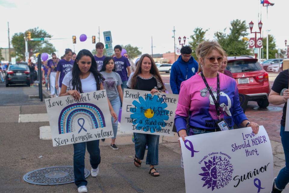 Members of the Amarillo community march to the Potter County Courthouse during the walk against domestic violence Monday afternoon in downtown Amarillo.