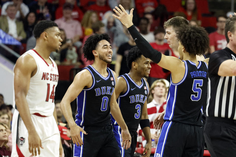 Duke's Jared McCain (0) celebrates after a play with teammates Tyrese Proctor (5), Kyle Filipowski (30) and Jeremy Roach (3) with North Carolina State's Casey Morsell (14) looking on during the second half of an NCAA college basketball game in Raleigh, N.C., Monday, March 4, 2024. (AP Photo/Karl B DeBlaker)