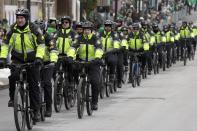 FILE - In this March 19, 2017, file photo, Boston Police patrol on bicycles during the annual St. Patrick's Day Parade in Boston. The city's police department remains largely white, despite vows for years by city leaders to work toward making the police force look more like the community it serves. (AP Photo/Michael Dwyer, File)