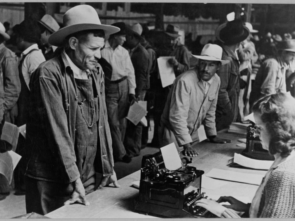 Mexican farm workers line up as they are registered to work in the US through the Bracero program, part of the Mexican Farm Labor Agreement, 1951.