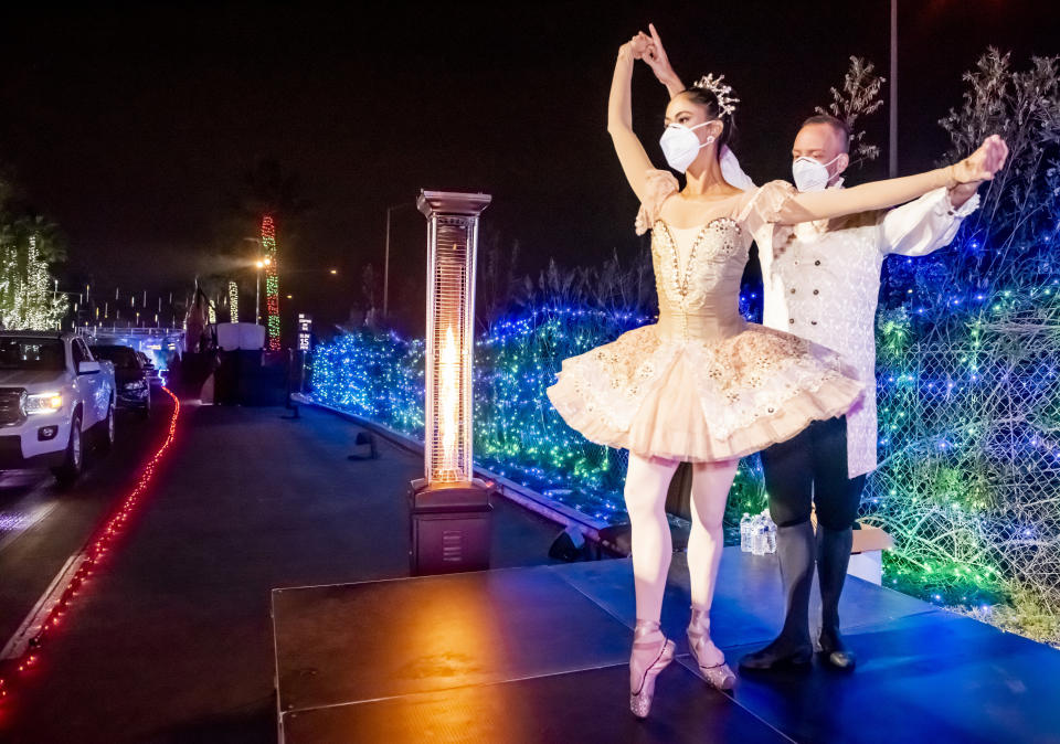 Dancers Susan Vishmid (left) and A.J. Abrams perform Dec. 13 for visitors touring the "Light of the World: Christmas Lights" drive-thru experience at Saddleback Church in Lake Forest, California. (Photo: Leonard Ortiz/Orange County Register via Getty Images)