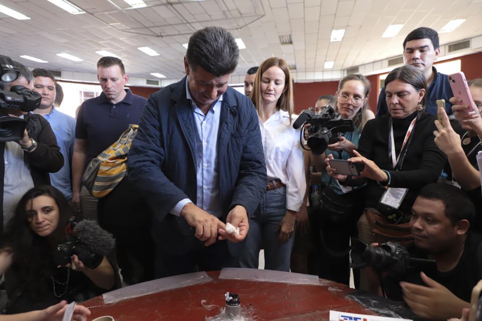 Efrain Alegre, presidential candidate for the Concertacion coalition, center left, cleans his finger after marking it with ink beside running mate Soledad Nunez at a polling station during general elections in Lambare, outskirts Asuncion, Sunday, April 30, 2023. (AP Photo/Marta Escurra)