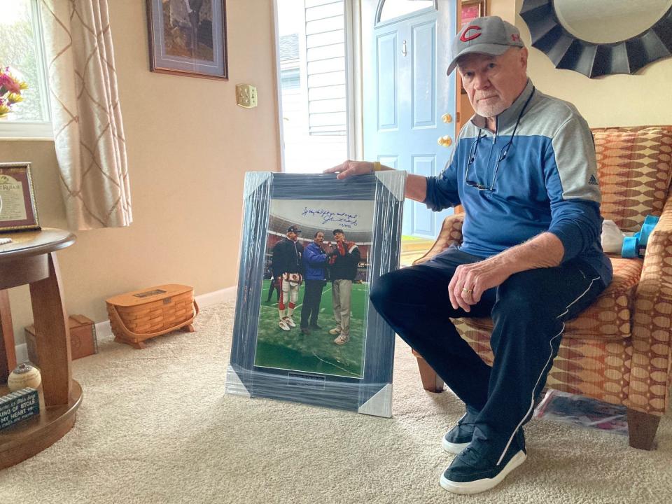Bill Renken sits in his Green Township home with one of the photos he took of O.J. Simpson at a 1991 Bengals game that was of interest to the prosecution. It's signed by Simpson attorney Johnnie Cochran.