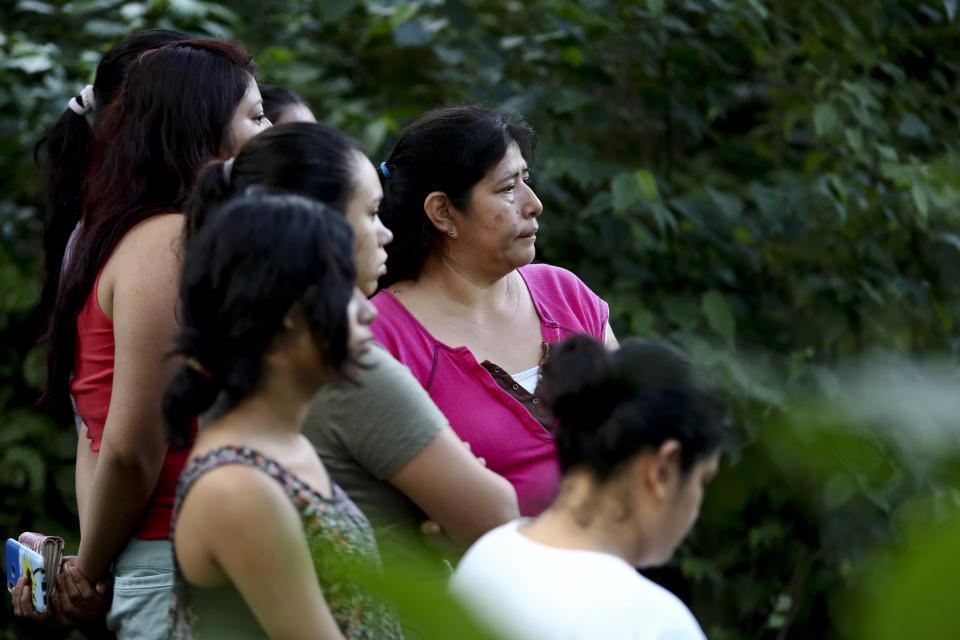 In this Oct. 13, 2019 photo, family and friends gather around the crime scene of slain ex-gang member, David Rivera, in San Salvador, El Salvador. Much of Central America’s massive migration of recent years has been out of fear of violence. (AP Photo/Eduardo Verdugo)