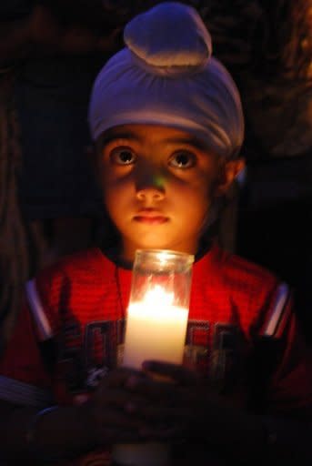 Akandeep Delam, 4, holds a candle on Monday at a vigil honouring six people killed in an attack on a Wisconsin Sikh temple the day before. A small US community struggled to understand Tuesday how a racist former soldier with links to white supremacists acted on his hatred and shot dead six unarmed people at a suburban Sikh temple