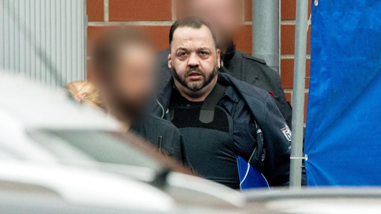 Der wegen vielfachen Mordes angeklagte Niels Högel wird von Justizbeamten zum Gefangenentransporter geführt. Foto: Hauke-Christian Dittrich