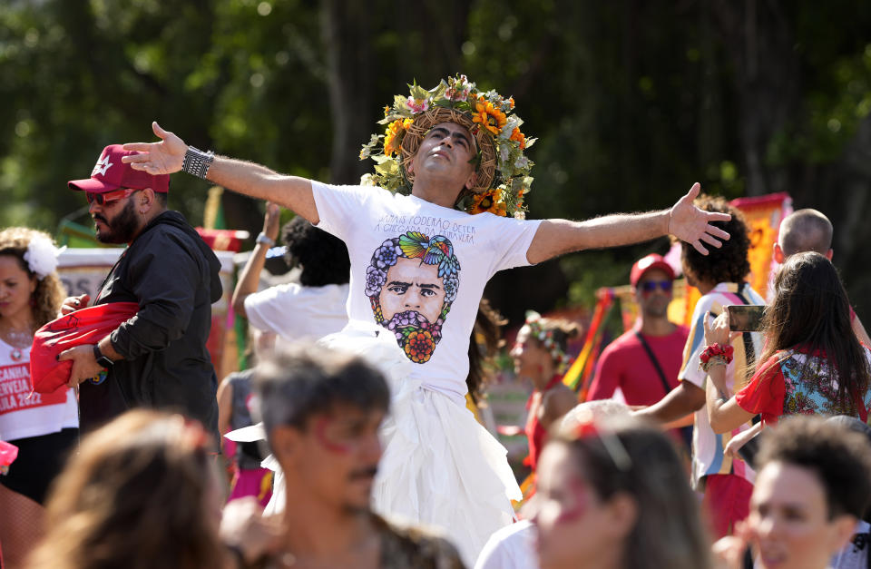 FILE - A man wearing a T-shirt featuring an image of Brazil's former President and now presidential candidate Luiz Inacio Lula da Silva, dances during a street block party in support of Lula, in Rio de Janeiro, Brazil, Sunday, Sept. 25, 2022. Brazil’s Oct. 2 presidential election is being contested by 11 candidates but only two stand a chance of reaching a runoff: da Silva and incumbent Jair Bolsonaro. (AP Photo/Silvia Izquierdo, File)