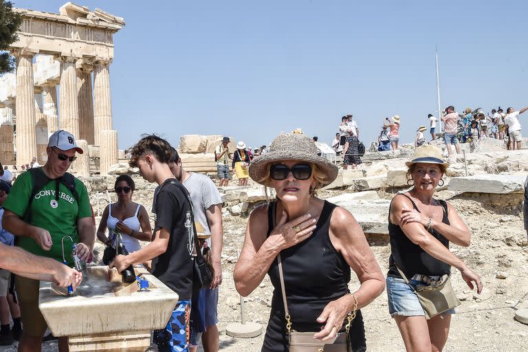 Los turistas se refrescan frente al Partenón, en Atenas, durante la ola de calor de julio pasado