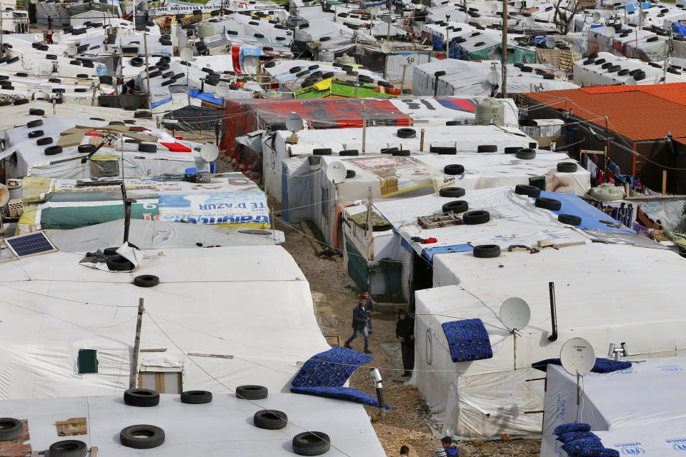 Syrian refugee stand outside their tents after heavy rain at a refugee camp, in the town of Bar Elias, in the Bekaa Valley, Lebanon, Jan. 10, 2019. (Photo: Bilal Hussein/AP)